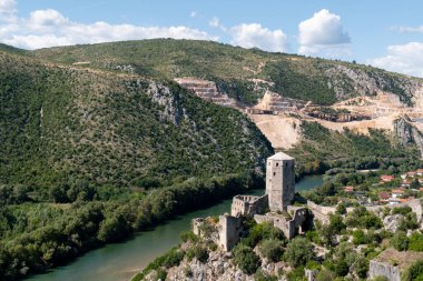 Ortaçağ Pocitelj kentindeki Gavran-Kapetanovic kulesi güneşli bir günde Neretva nehrinin kıyısında