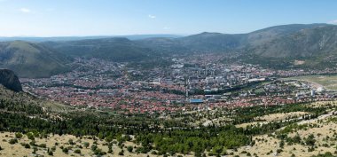 Mostar 'ın yüksek panoramik manzarası dağlarla çevrili, güneşli bir yaz günü.