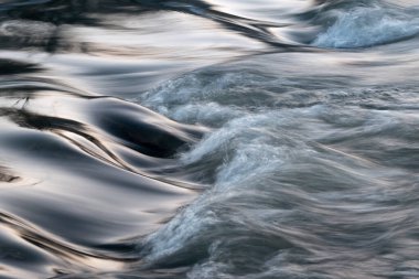 Hızlı su taşlı dipten akarak çağlayanı oluşturur - soyut manzara yakın