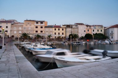 Alacakaranlıkta Pag Limanı, uzun süre açık, hareket halindeki tekneler bulanık.