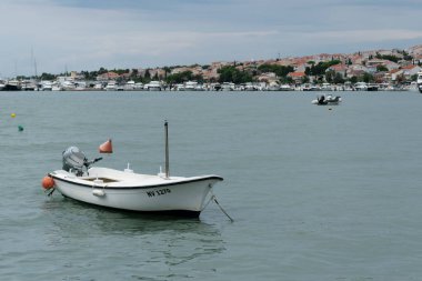 Bulutlu bir günde Adriyatik Denizi kıyısında demirli motorlu tekne