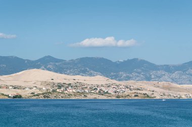 Pag Adası 'nda kıyı yerleşkesi ve Velebit Dağı sisli