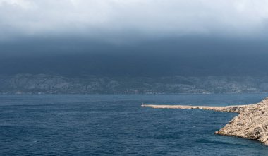 Dalgalı deniz manzarası ve Dalmaçya 'daki Velebit dağının tepesinde kara fırtınalı bulutlar, tehlikeli hava