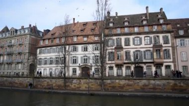 Saint Thomas rıhtımındaki binalar, insanlar soğuk havada sıcak giysiler içinde yürür.