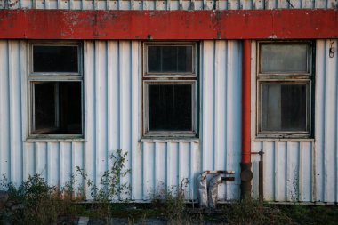 Pencereleri olan endüstriyel terk edilmiş bir bina, eski bir pastane, eğimli metal levhalardan yapılmış.