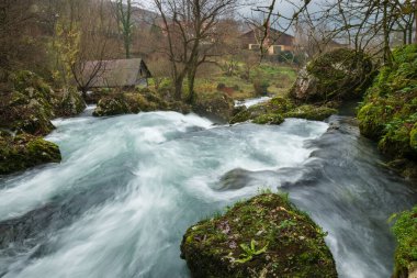 Hızlı dağ deresi Krupa 'da şelaleler, ahşap su değirmenleri, turkuaz renkli temiz su.