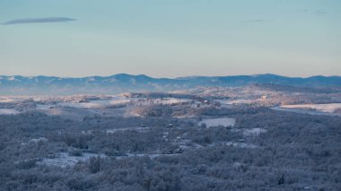 Soğuk kış gecesinden sonra buzla kaplı tepe köyü, yaprak döken orman ve tarlalar sabah güneşiyle yıkandı, dağ sıraları kadar uzaktı.