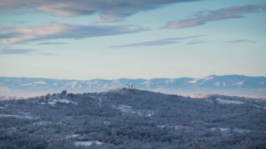 Soğuk kış gecesinden sonra buzla kaplı tepe köyü tepenin üstünde orman ve dağ sıralarıyla çevrili bir kilise var.