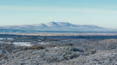 Şafak vakti uzak dağlarla güneş ışığı ve kışın manzarası