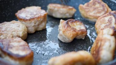 Kızartma tavasındaki çörekleri çevirerek, buğday unundan yapılmış, sıcak tabakta pişmesini önlüyorlar.