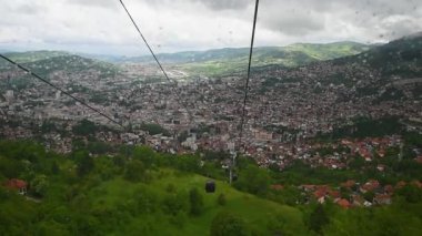 Bulutlu ve yağmurlu bir günde Vlasiç dağından Saraybosna 'ya teleferiğe bin, rüzgar kalkanına yağmur damlaları düşsün