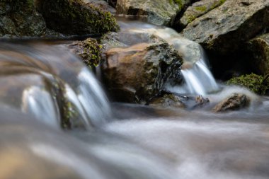 Hızlı dağ akıntısı, kayalık dipten akarak çağlayan kayalar, kayaların üzerinde mırıldanan berrak sular ve yosun kaplı kayalar oluşturur.