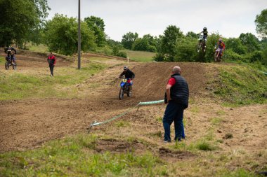 Bulutlu bir günde çamurlu yolda motokros sürücüleri yeteneklerini gösteriyorlar.