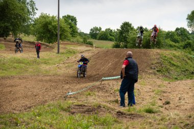 Bulutlu bir günde çamurlu yolda motokros sürücüleri yeteneklerini gösteriyorlar.