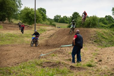 Bulutlu bir günde çamurlu yolda motokros sürücüleri yeteneklerini gösteriyorlar.