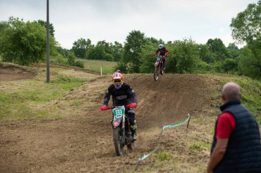 Bulutlu bir günde çamurlu yolda motokros sürücüleri yeteneklerini gösteriyorlar.