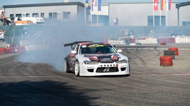 Yanan lastiklerden gelen dumanlar yüzünden araba raylarda sürükleniyor.