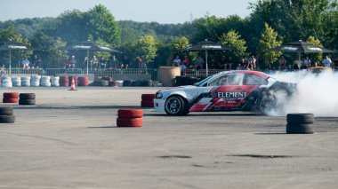 Yanan lastiklerden gelen dumanlar yüzünden araba raylarda sürükleniyor.