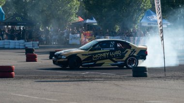 Yanan lastiklerden gelen dumanlar yüzünden araba raylarda sürükleniyor.