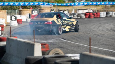 Yanan lastiklerden gelen dumanlar yüzünden araba raylarda sürükleniyor.