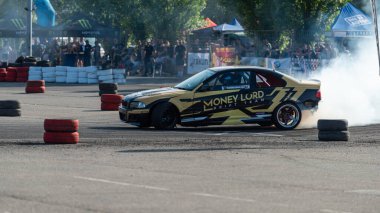 Yanan lastiklerden gelen dumanlar yüzünden araba raylarda sürükleniyor.