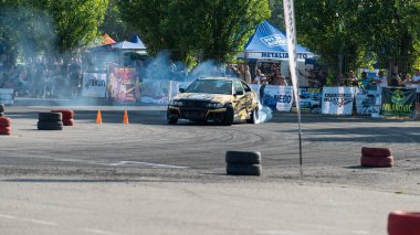 Yanan lastiklerden gelen dumanlar yüzünden araba raylarda sürükleniyor.