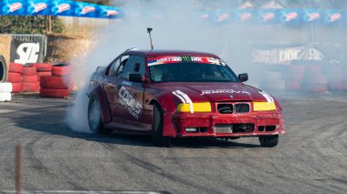 Yanan lastiklerden gelen dumanlar yüzünden araba raylarda sürükleniyor.