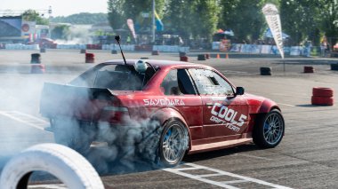 Yanan lastiklerden gelen dumanlar yüzünden araba raylarda sürükleniyor.