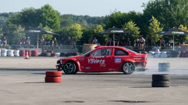 Yanan lastiklerden gelen dumanlar yüzünden araba raylarda sürükleniyor.