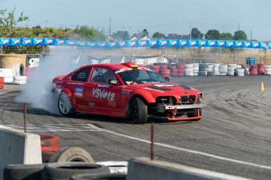 Yanan lastiklerden gelen dumanlar yüzünden araba raylarda sürükleniyor.