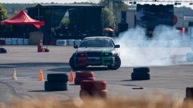 Yanan lastiklerden gelen dumanlar yüzünden araba raylarda sürükleniyor.