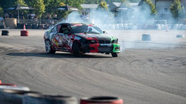 Yanan lastiklerden gelen dumanlar yüzünden araba raylarda sürükleniyor.