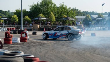 Yanan lastiklerden gelen dumanlar yüzünden araba raylarda sürükleniyor.