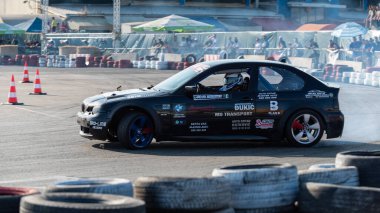 Yanan lastiklerden gelen dumanlar yüzünden araba raylarda sürükleniyor.