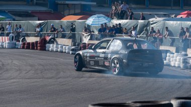 Yanan lastiklerden gelen dumanlar yüzünden araba raylarda sürükleniyor.