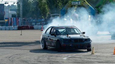 Yanan lastiklerden gelen dumanlar yüzünden araba raylarda sürükleniyor.