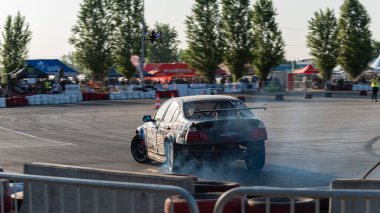 Yanan lastiklerden gelen dumanlar yüzünden araba raylarda sürükleniyor.