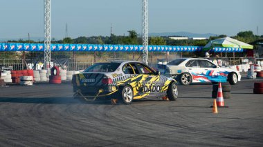 Yanan lastiklerden gelen dumanlar yüzünden araba raylarda sürükleniyor.