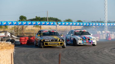 Yanan lastiklerden gelen dumanlar yüzünden araba raylarda sürükleniyor.