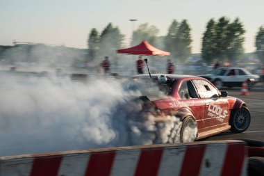 Yanan lastiklerden gelen dumanlar yüzünden araba raylarda sürükleniyor.