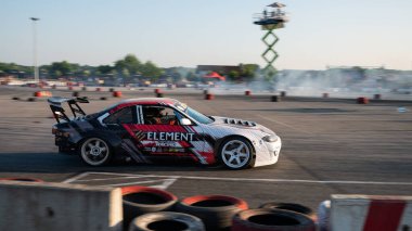 Yanan lastiklerden gelen dumanlar yüzünden araba raylarda sürükleniyor.