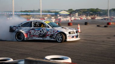 Yanan lastiklerden gelen dumanlar yüzünden araba raylarda sürükleniyor.