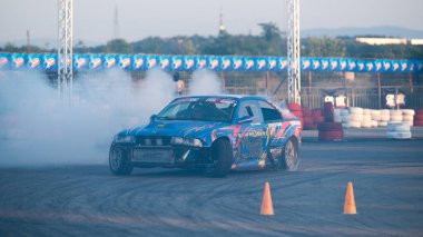 Yanan lastiklerden gelen dumanlar yüzünden araba raylarda sürükleniyor.