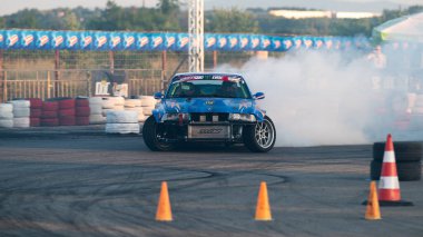 Yanan lastiklerden gelen dumanlar yüzünden araba raylarda sürükleniyor.