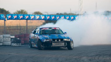 Yanan lastiklerden gelen dumanlar yüzünden araba raylarda sürükleniyor.