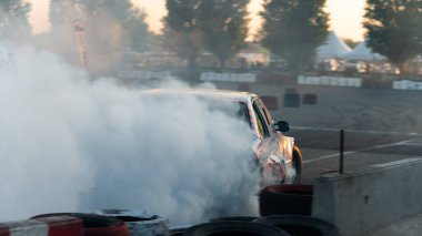 Yanan lastiklerden gelen dumanlar yüzünden araba raylarda sürükleniyor.