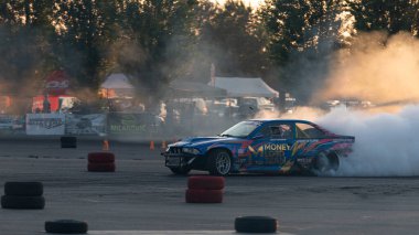 Yanan lastiklerden gelen dumanlar yüzünden araba raylarda sürükleniyor.