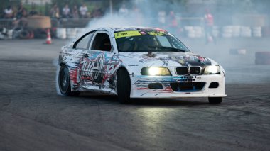 Yanan lastiklerden gelen dumanlar yüzünden araba raylarda sürükleniyor.