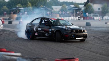 Yanan lastiklerden gelen dumanlar yüzünden araba raylarda sürükleniyor.