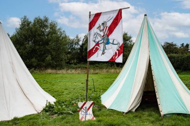 Kenilworth Şatosu Şövalyeleri çadırlarının önünde bayrak sallıyor. 